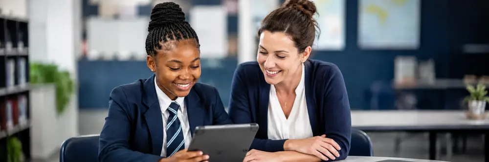 Onderwyser en leerder wat 'n verkiesing op 'n tablet hersien